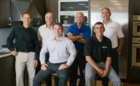 Members of the Schneider family and Silica leadership in an appliance showroom