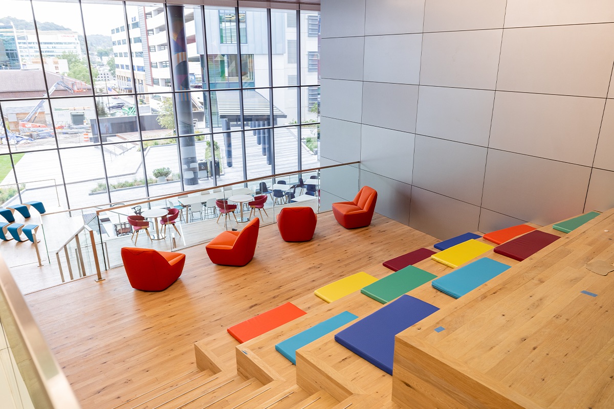 Colorful stepped seating and red chairs inside the Conshohocken headquarters