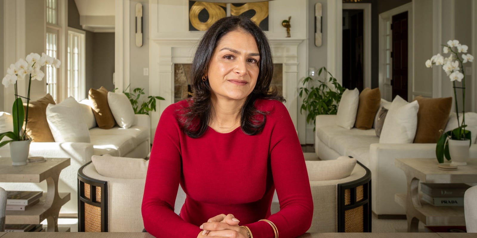 Sima Sistani in a red sweater, seated at a table in a light-filled room