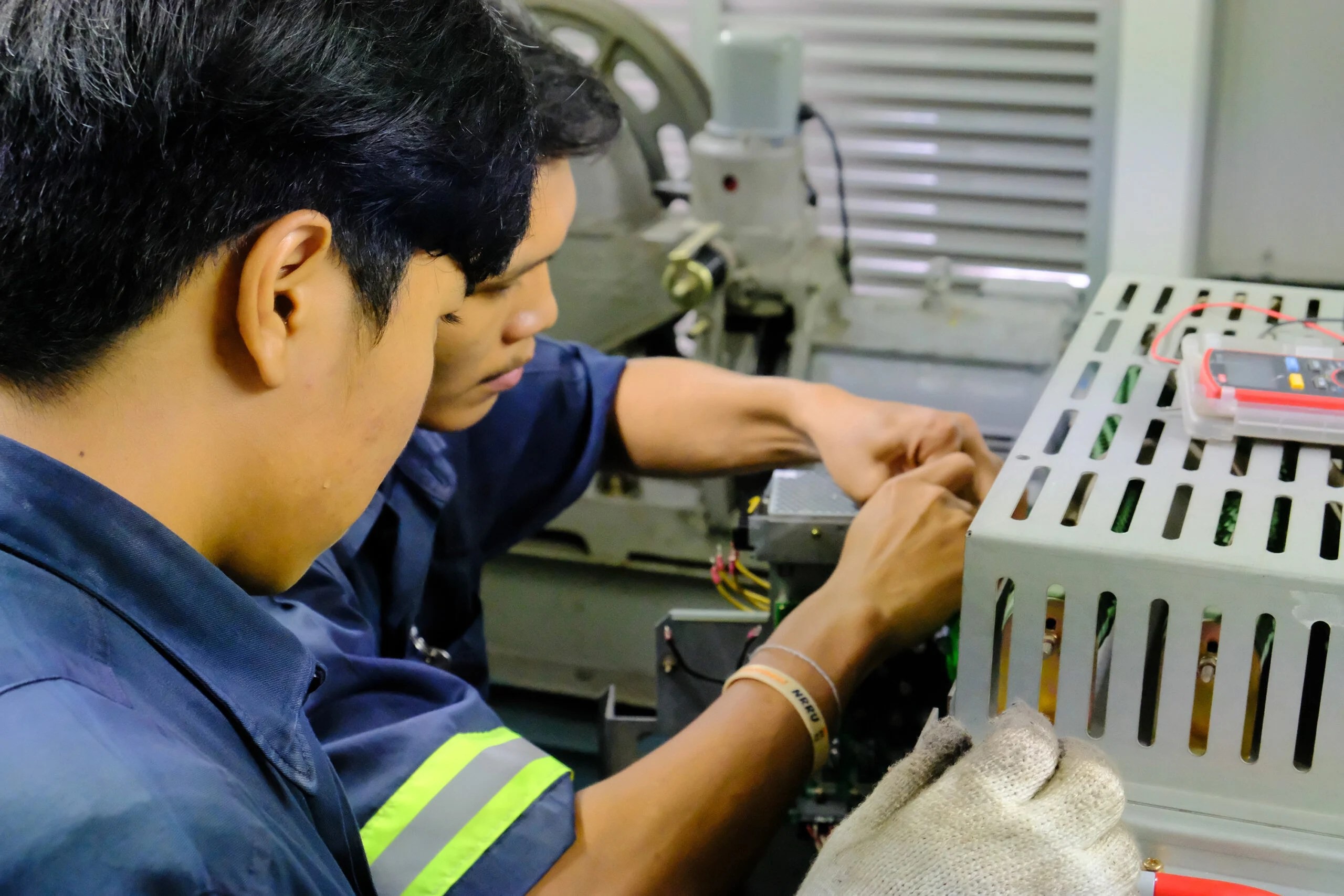 Two technicians working closely on equipment in SIMCO’s onsite calibration photograph