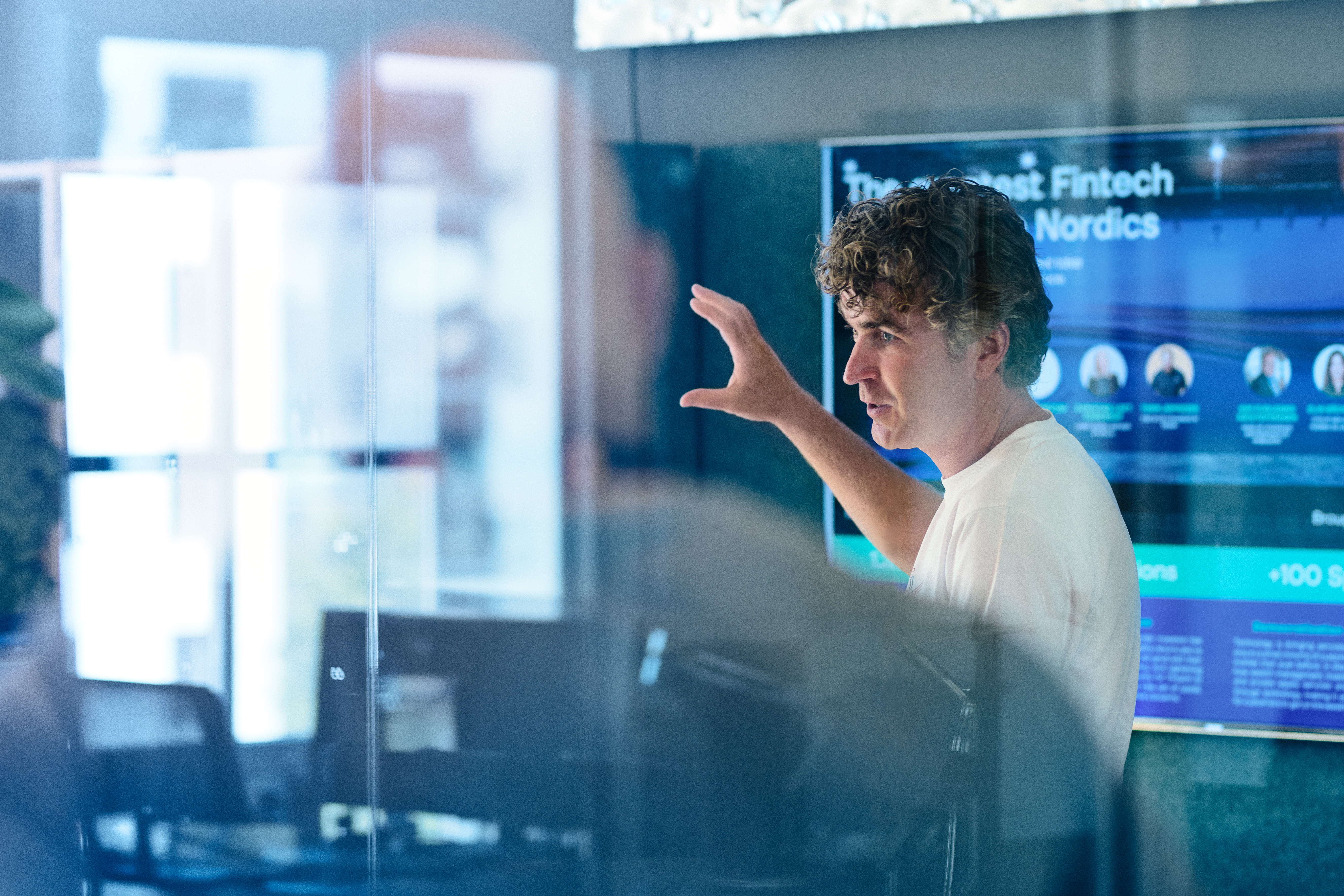 Simon Schou gesturing while giving a presentation at Copenhagen Fintech