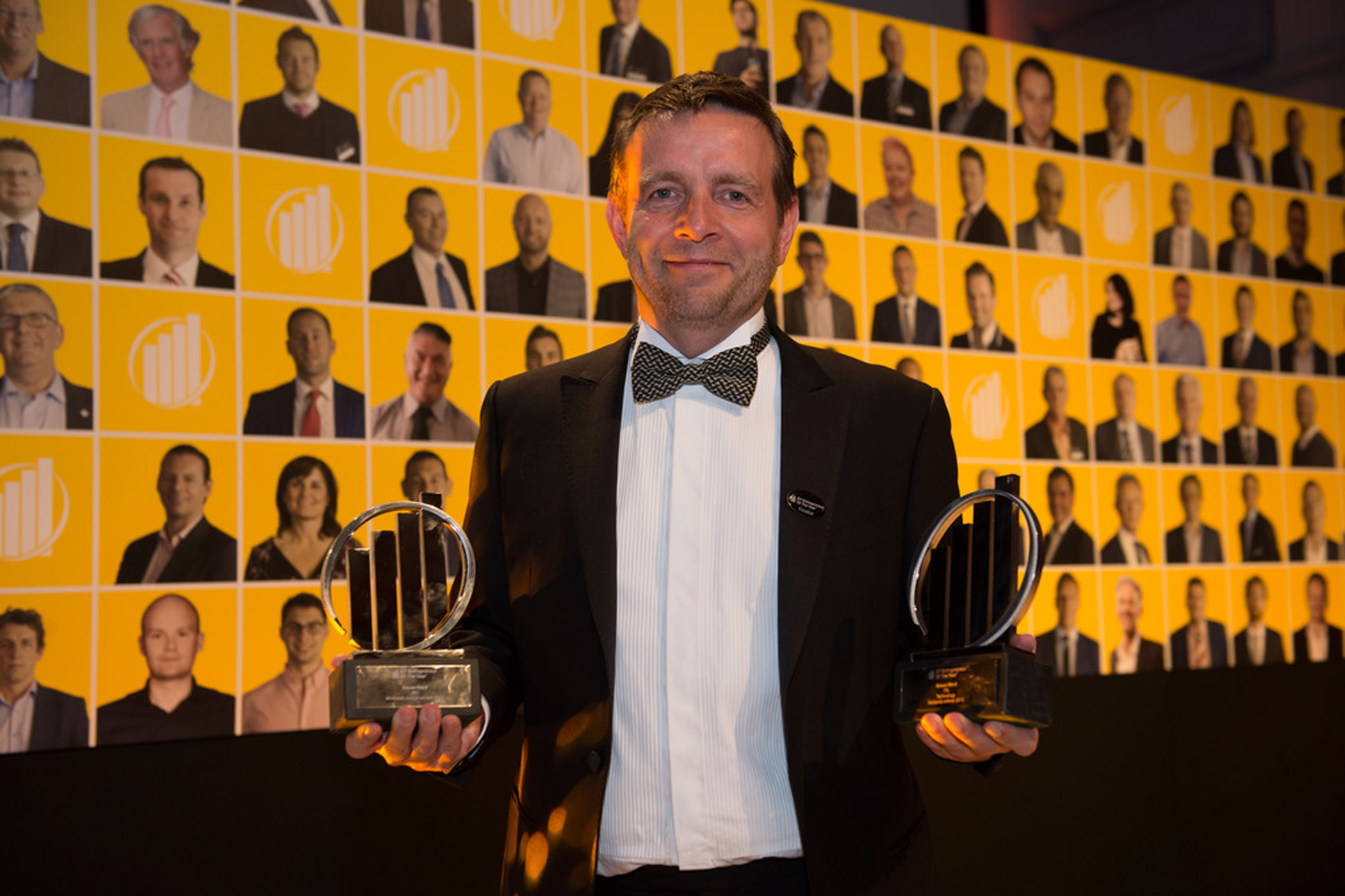 Simon Ward holding his two Midlands EY awards in 2015