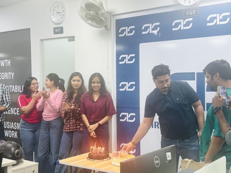 Siri InfoSolutions colleagues gathered around two birthday cakes in an office
