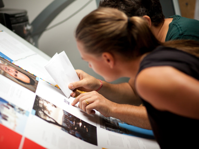 Sissel Hansen leaning over printed Startup Guide pages during a close review