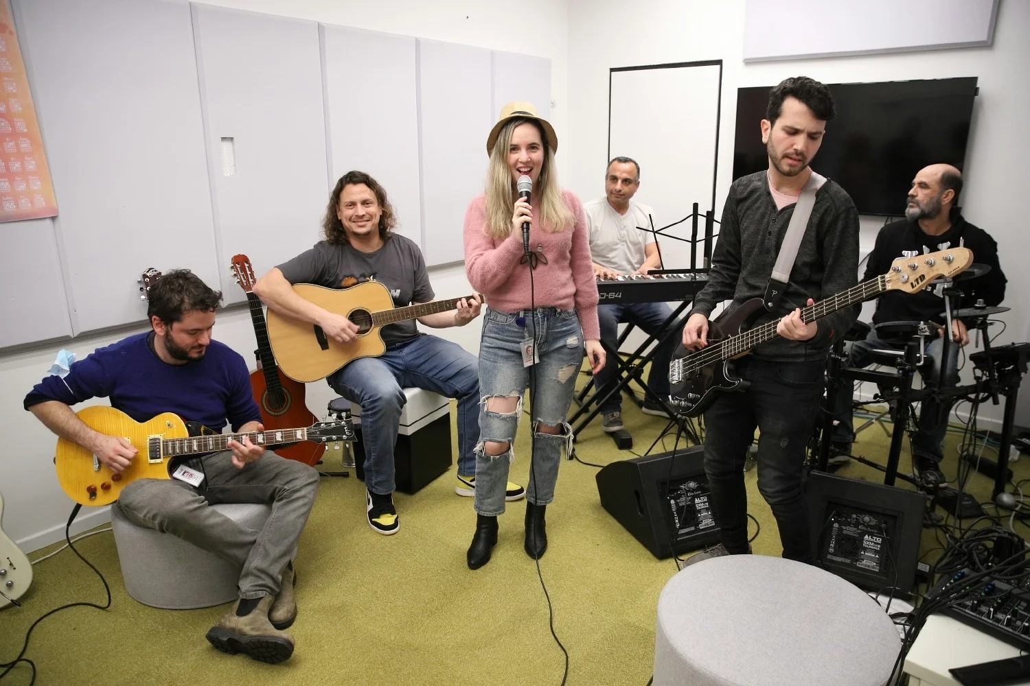 Skai employees playing guitars, bass, keyboards and drums while a colleague sings