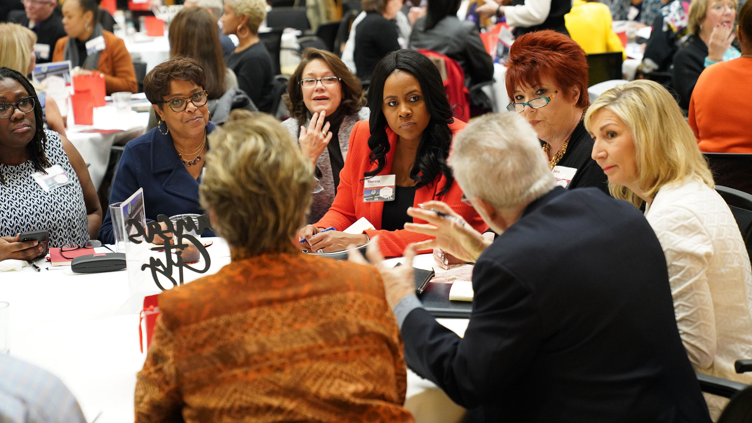 SkillPath trainers discussing their work around a table at a trainers conference