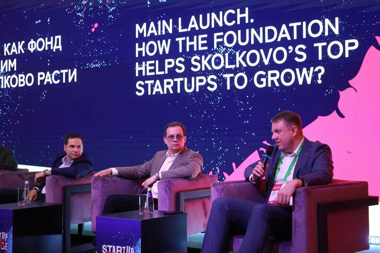 Panelists discuss startup growth at Startup Village 2026, beneath a large bilingual stage display