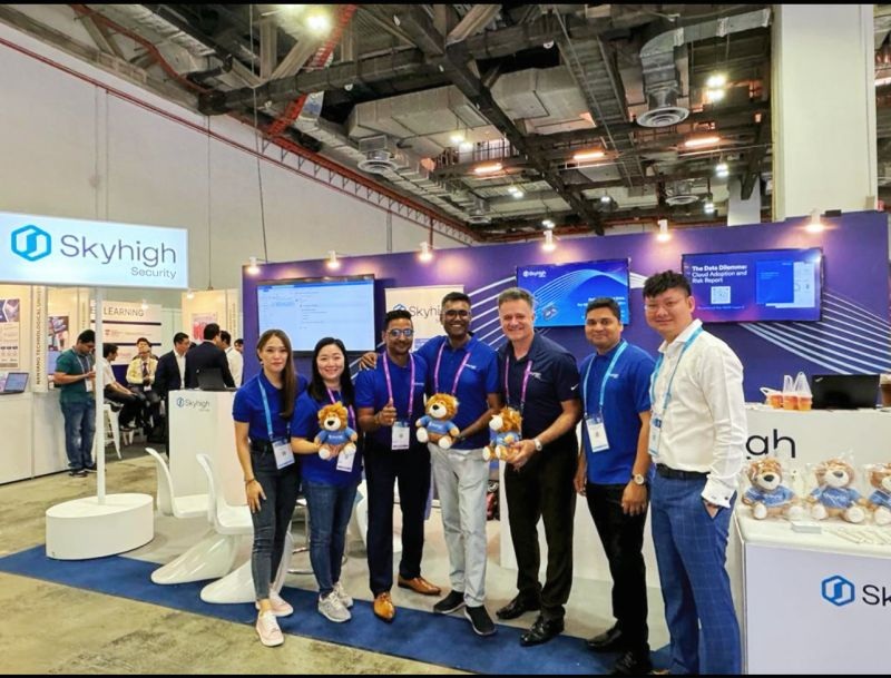 Skyhigh Security representatives holding branded plush lions at their GovWare 2023 booth