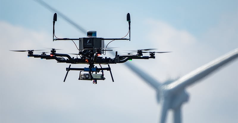 SkySpecs inspection drone flying near a wind turbine