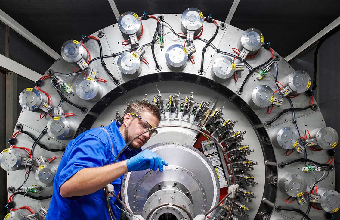 SLB operator inspecting a large circular assembly of industrial machinery