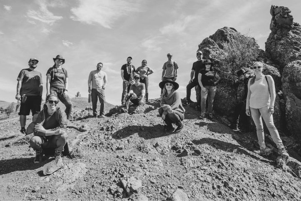 Sleepless Media team members gathered on a rocky outdoor landscape