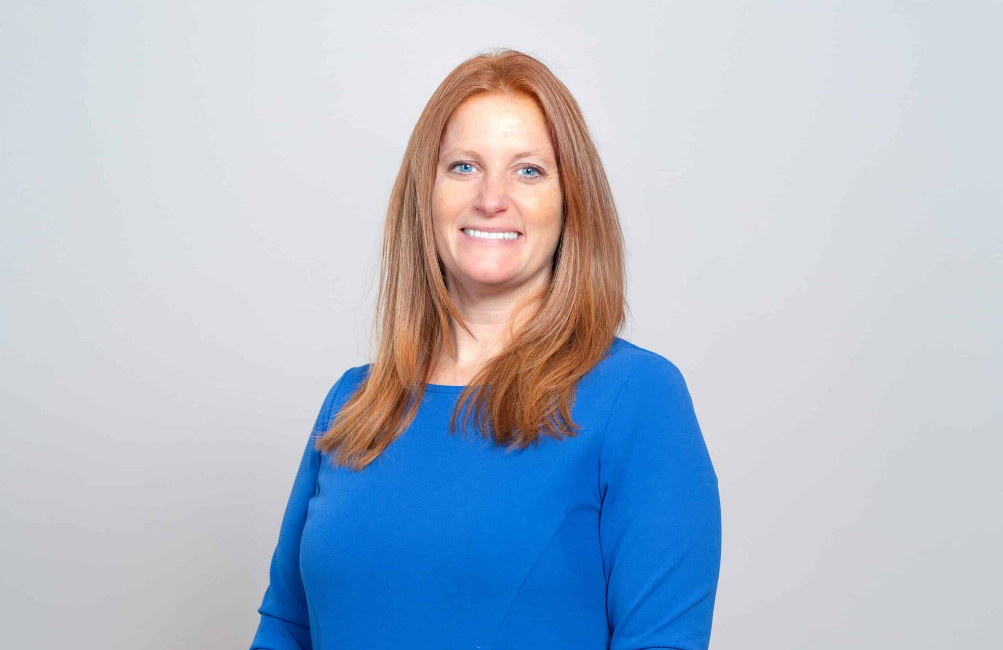 Cassandra Bailey, founder and CEO of Slice Communications, in a blue dress against a light background