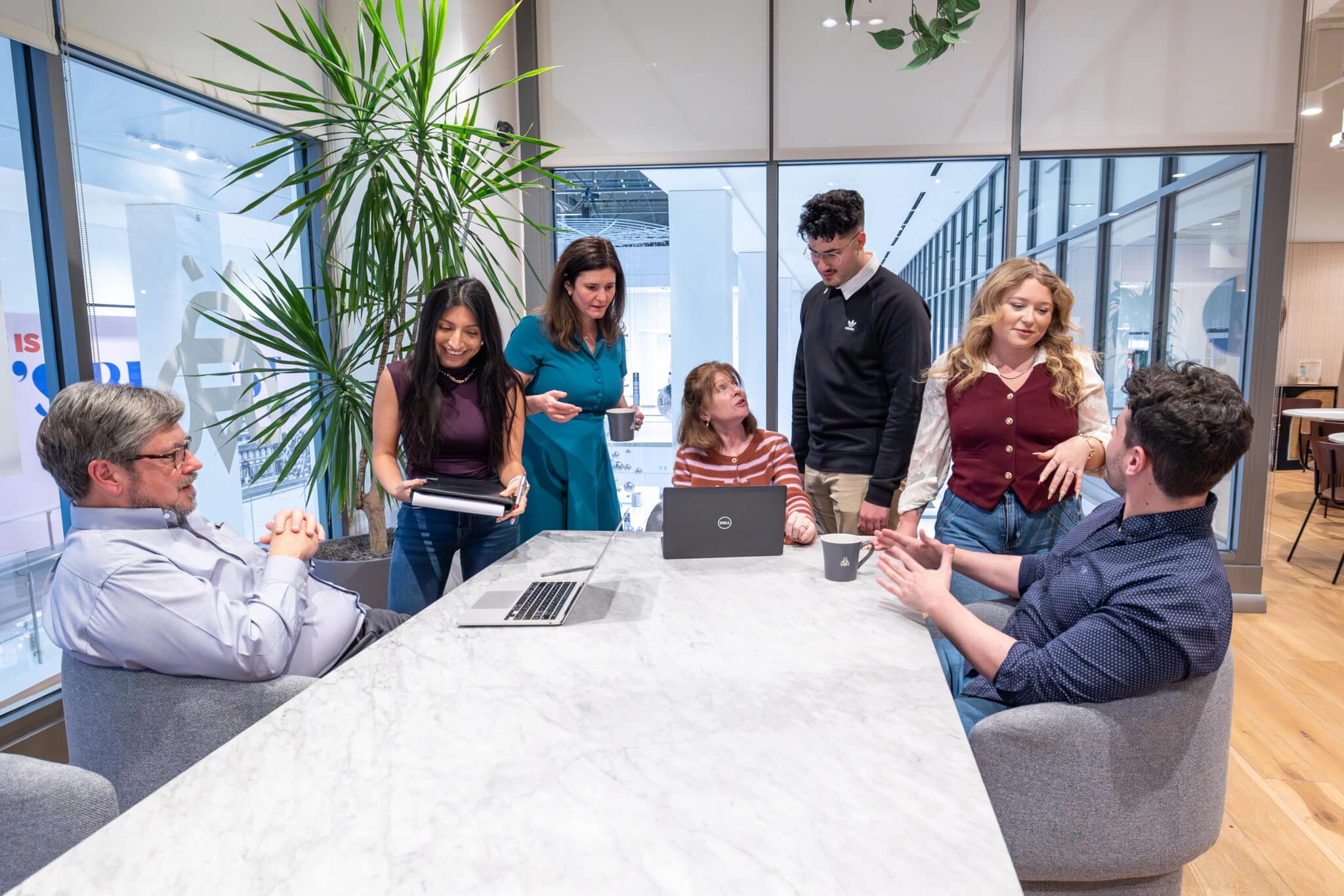 A Slice Communications team gathered around a table in a bright office