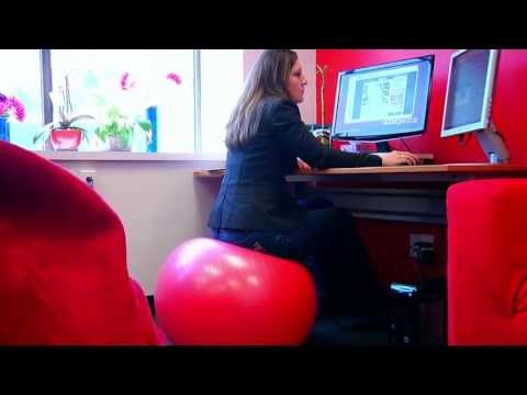 A SlideGenius designer works at a desktop computer in an office
