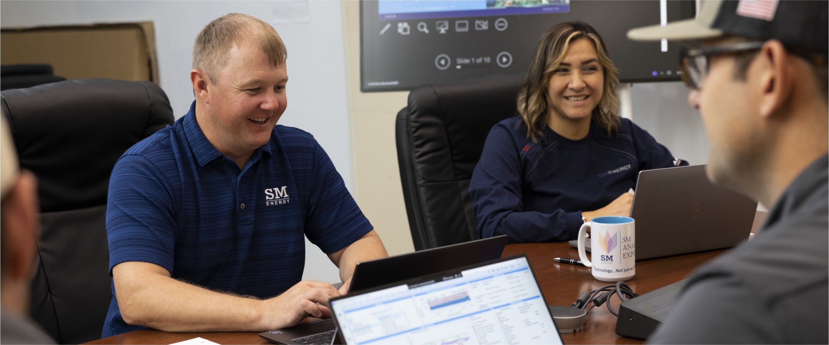 SM Energy colleagues working together around laptops in a meeting room