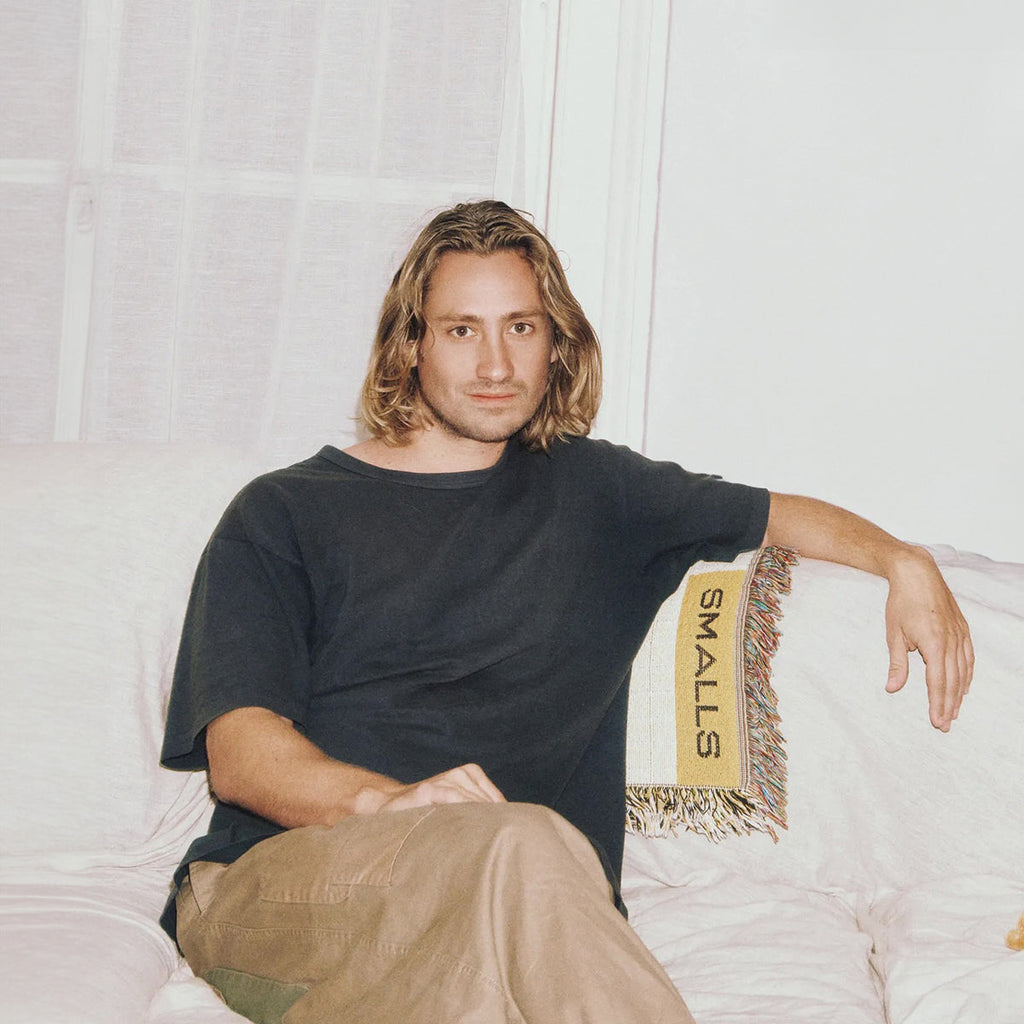 Smalls co-founder Matt Michaelson seated beside a Smalls blanket