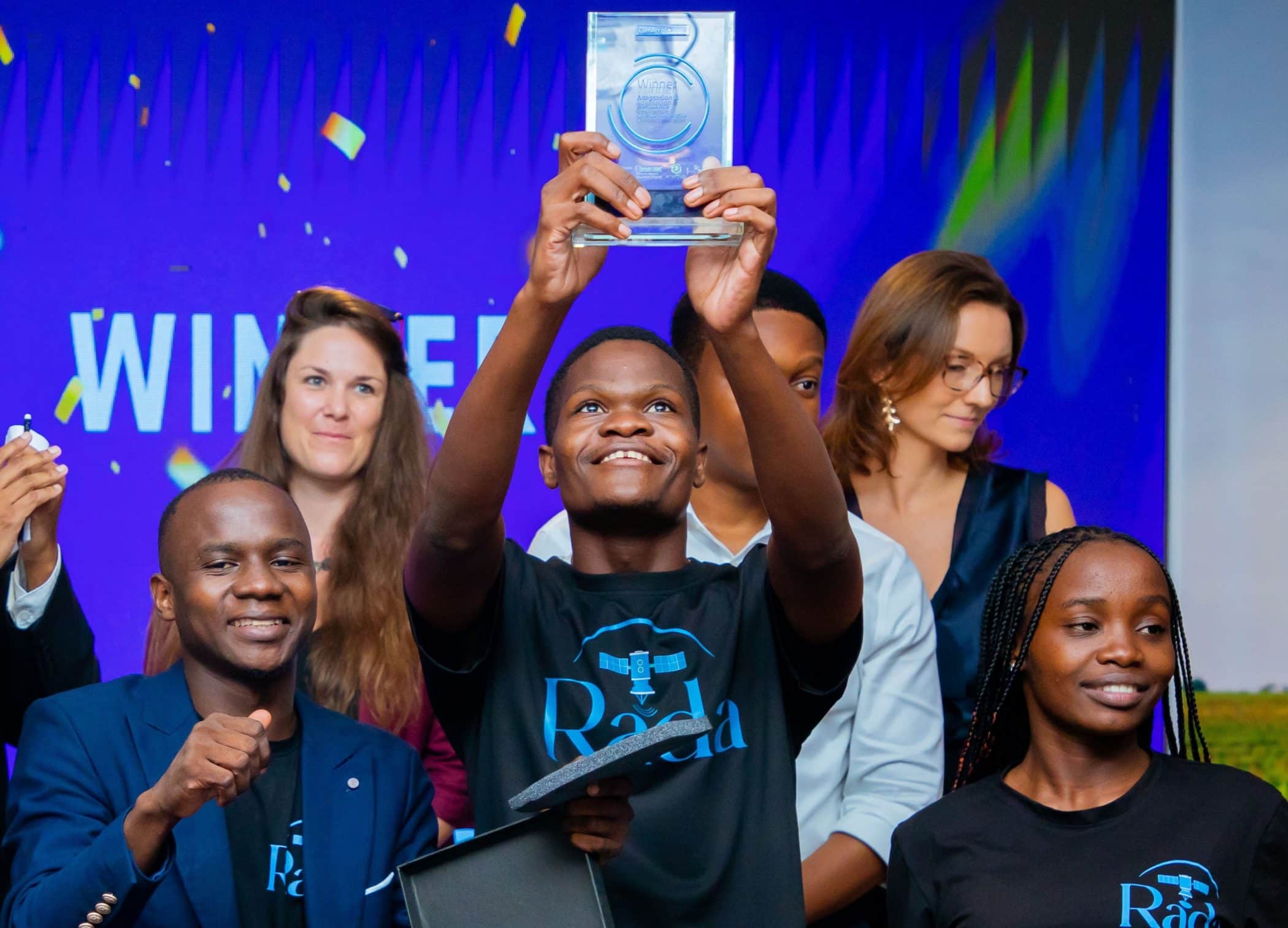 Rada 360 participants celebrate with a trophy at Tanzania’s 2025 climate accelerator demo day