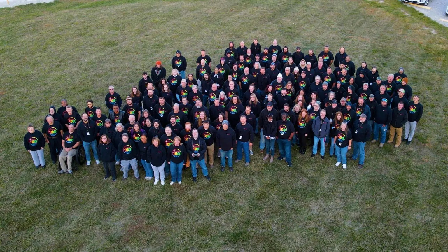 Smithville employees gathered outdoors wearing centennial shirts