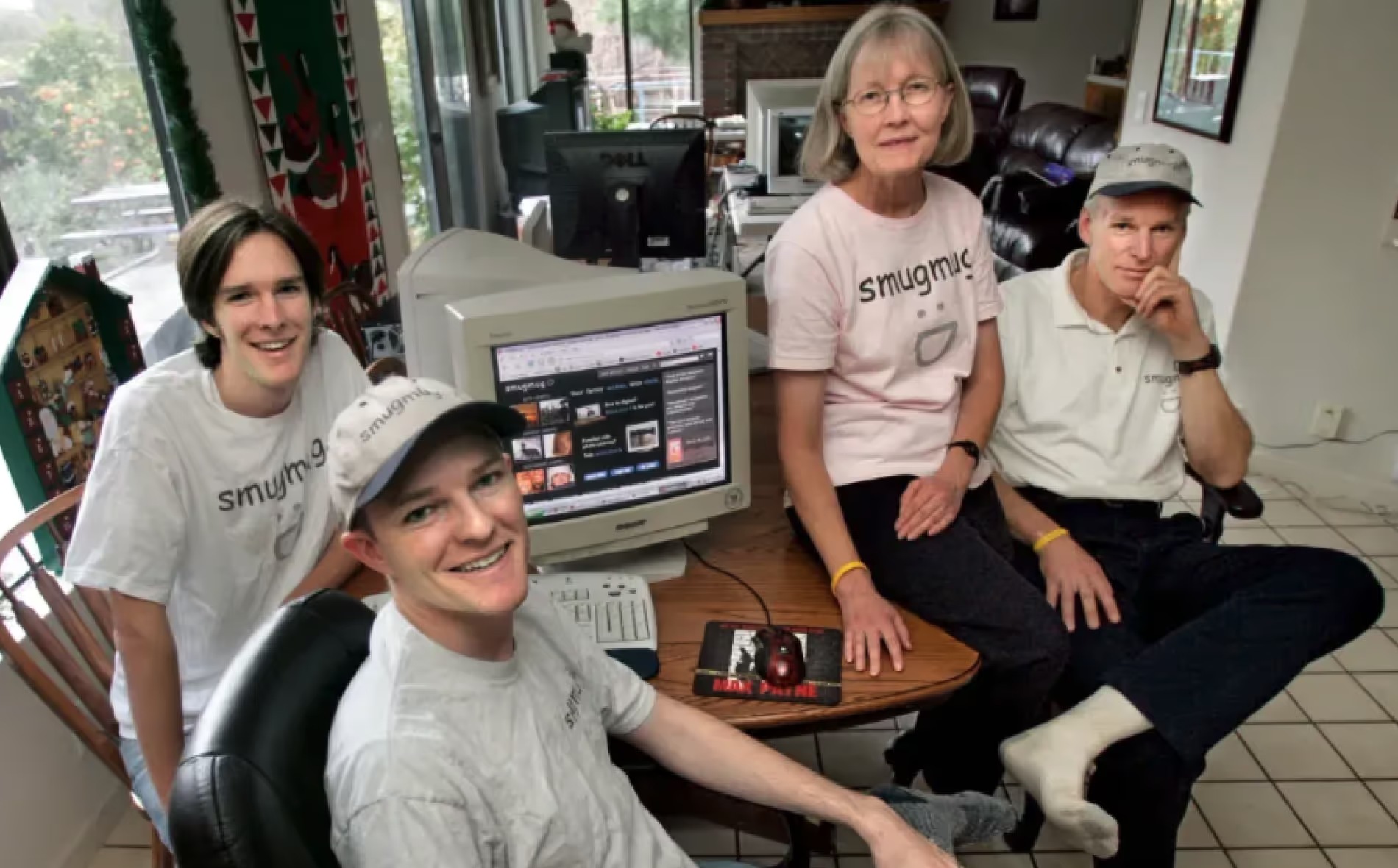 SmugMug's early family team gathered around a desktop computer in a home office