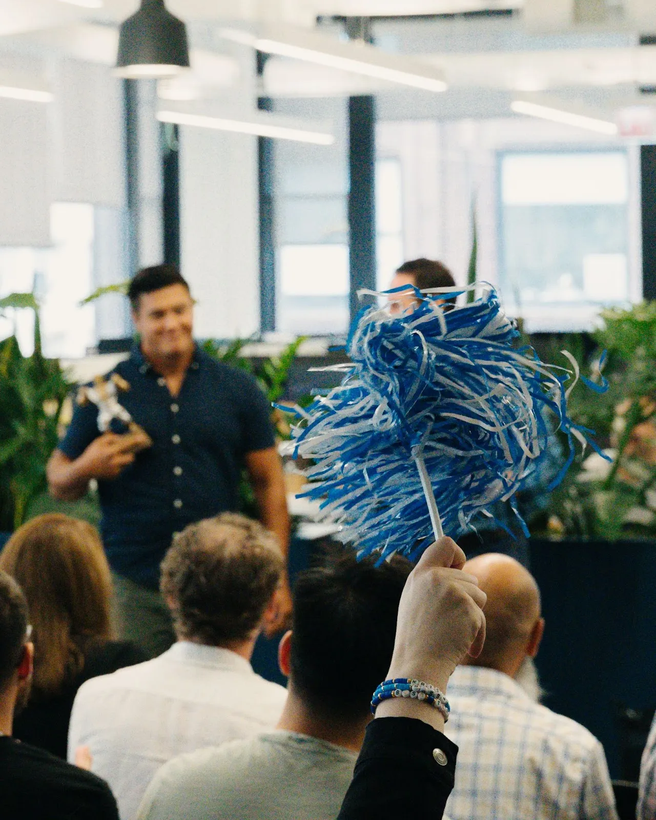 Snapsheet colleagues gathering at the 2023 Summit, with a blue and white pom-pom in the foreground