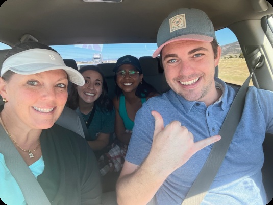 Four Snoball team members smiling in a car in a photograph published on the company’s about page.