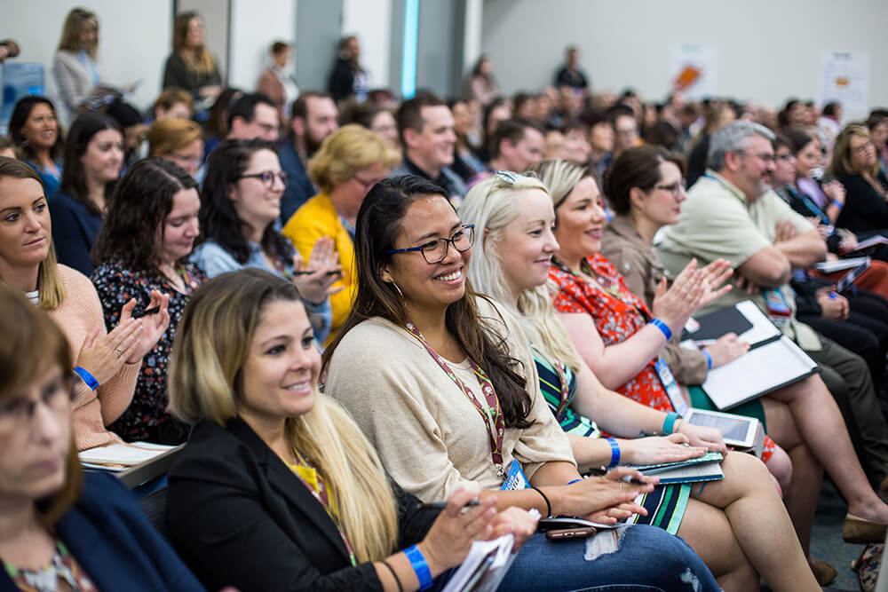 Marketers seated together and applauding at Social Media Marketing World