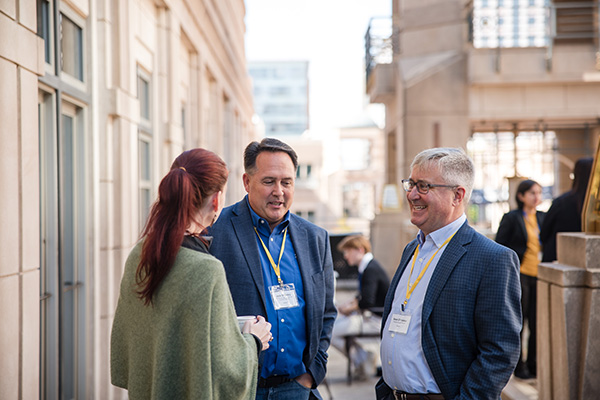 Three people in conversation at a Softeon company event