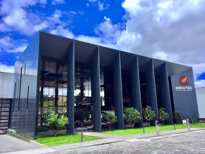 Endutex premises with tall dark columns, trees and the company sign