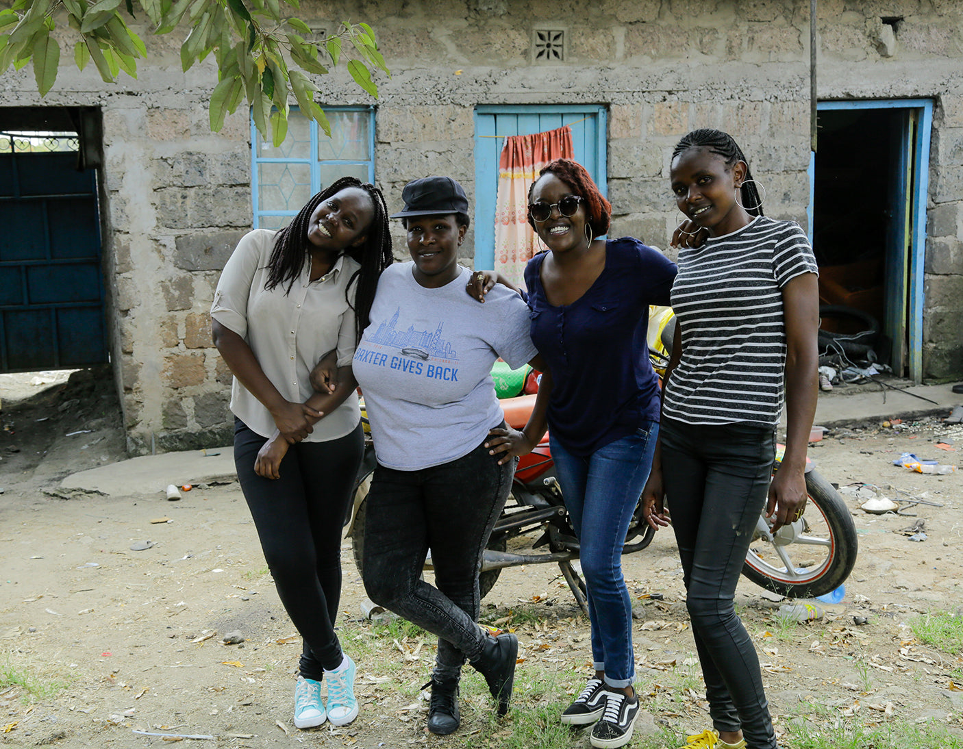 Four women standing outside a stone building in a photograph from SOKO's About page