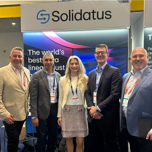 Five Solidatus team members standing at a company conference booth