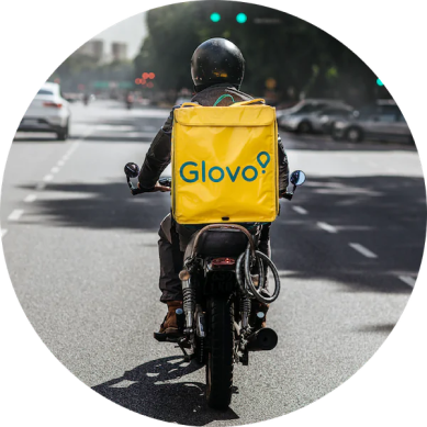 A Glovo courier riding through a city street