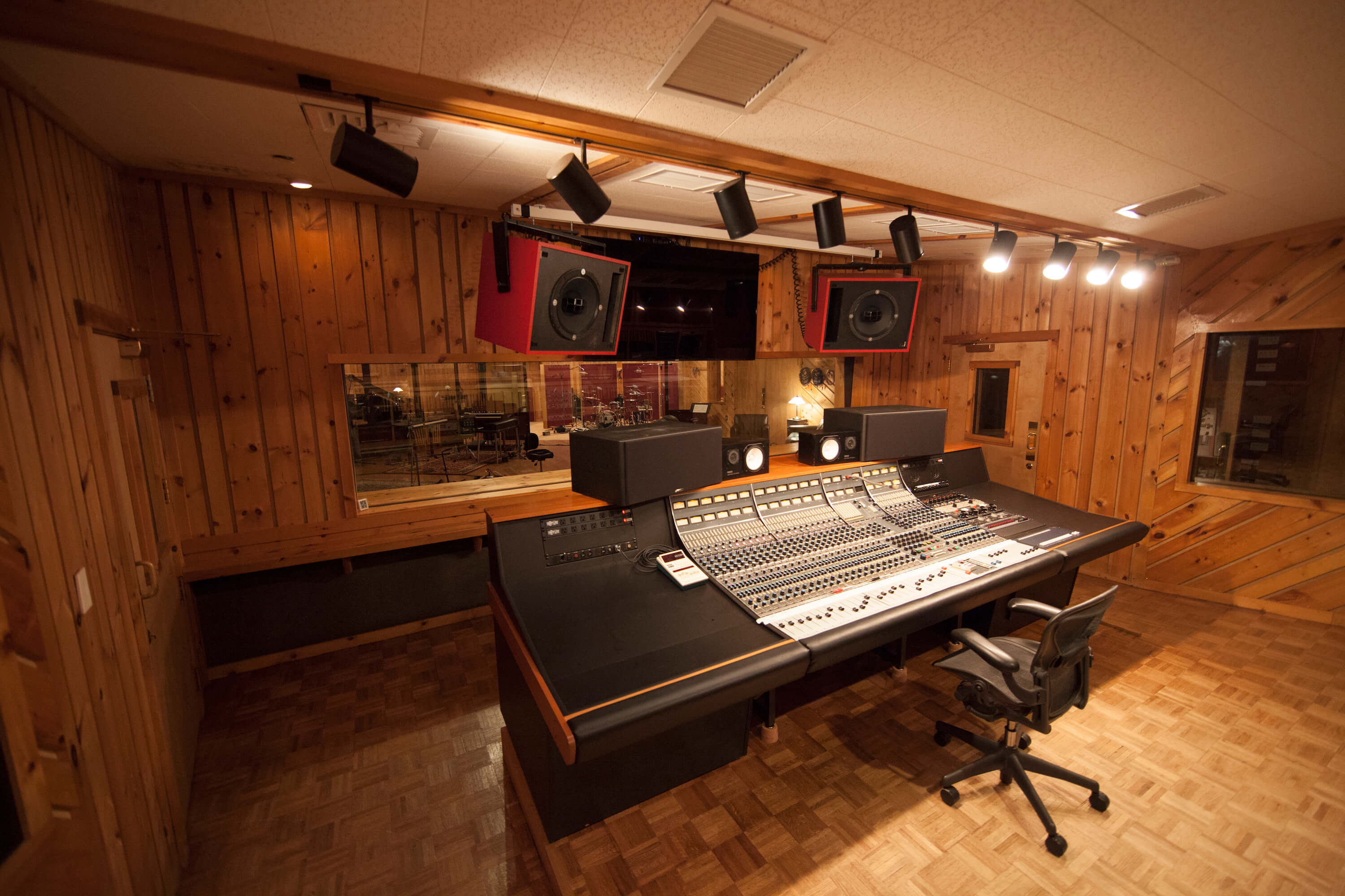 Wood-paneled control room with an analog mixing console at Power Station New England