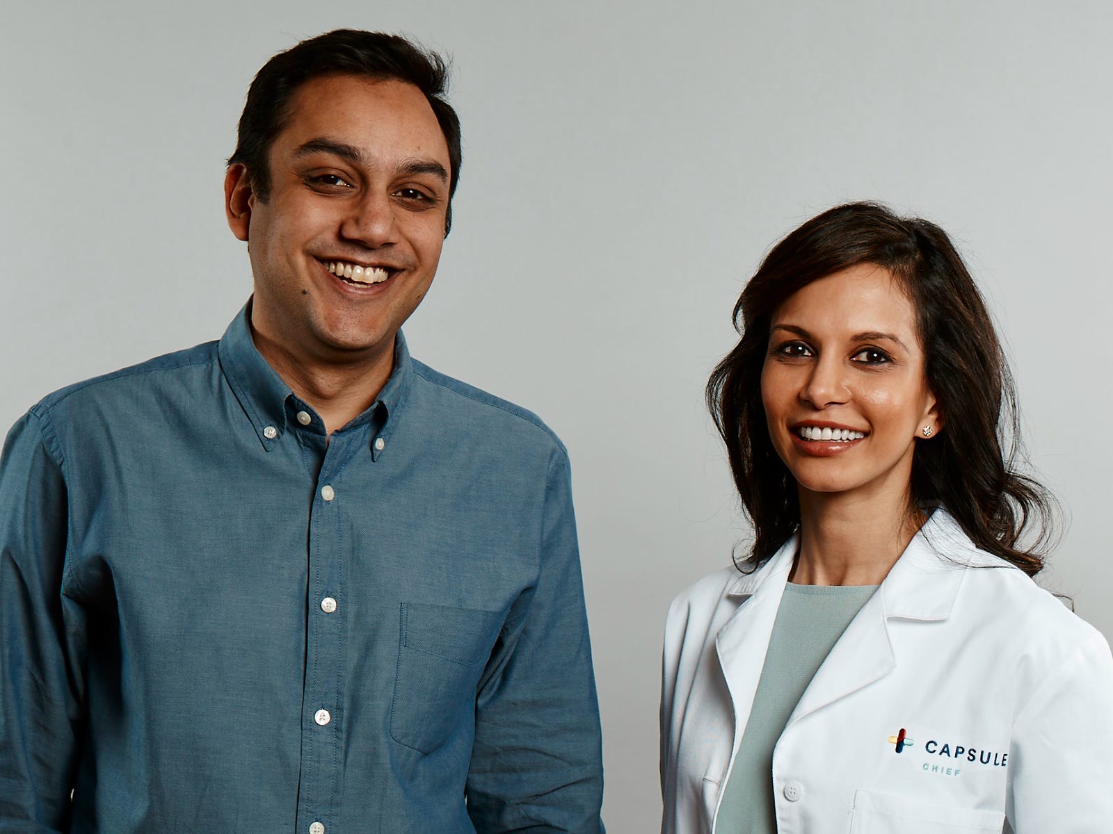 Capsule founder Eric Kinariwala and founding team member Sonia Patel Jain standing together against a gray background