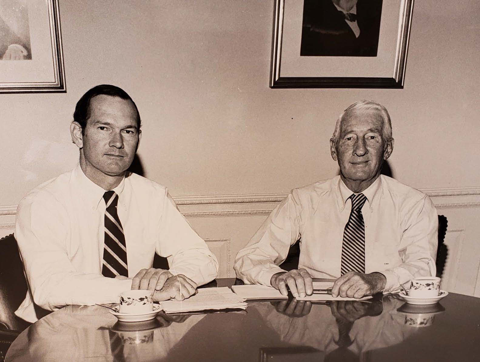 Charlie Coker at left seated at a table with his father