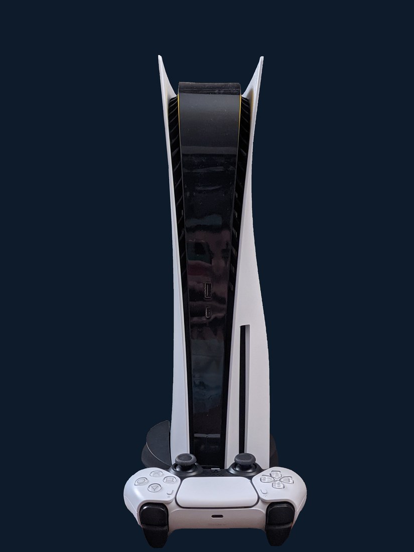PlayStation 5 console standing vertically with a DualSense controller