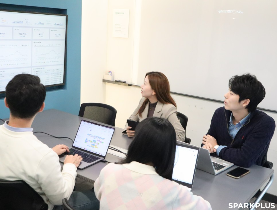 Sophie Eom and colleagues gathered around laptops in a meeting room