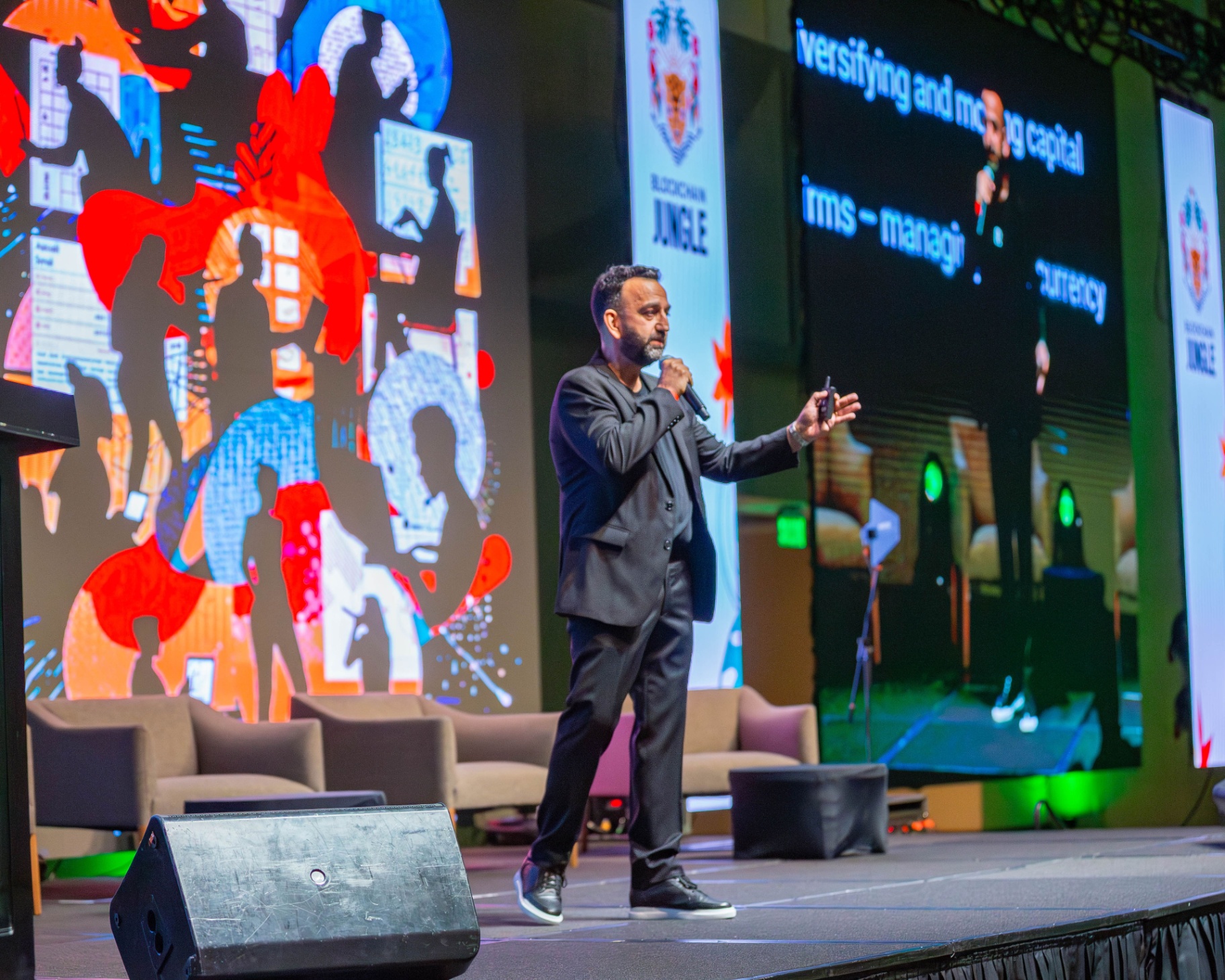 Soren Azorian speaking into a handheld microphone on a conference stage