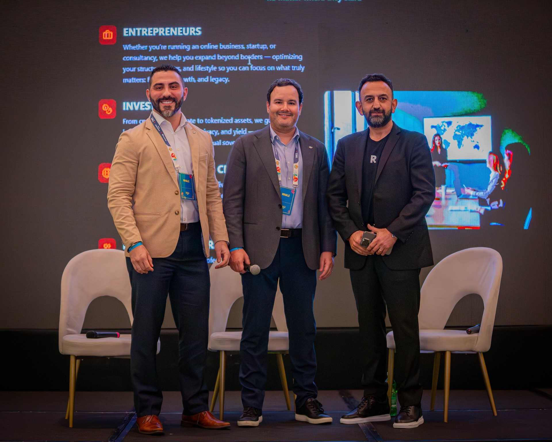 Soren Azorian, at right, standing with two other attendees on a conference stage