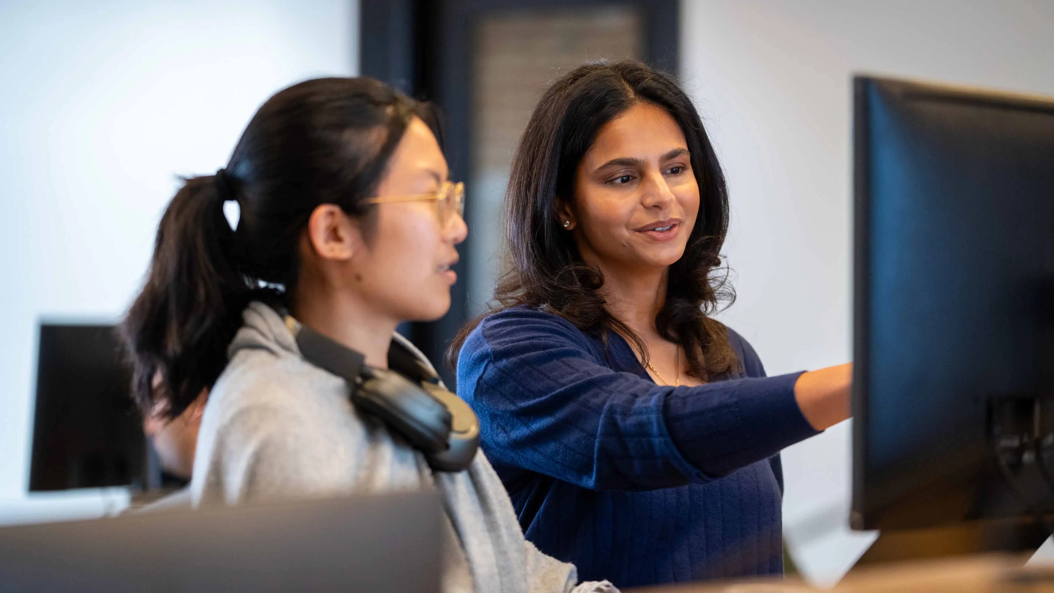 Ruchi Sanghvi collaborating with a colleague at a computer at SPC