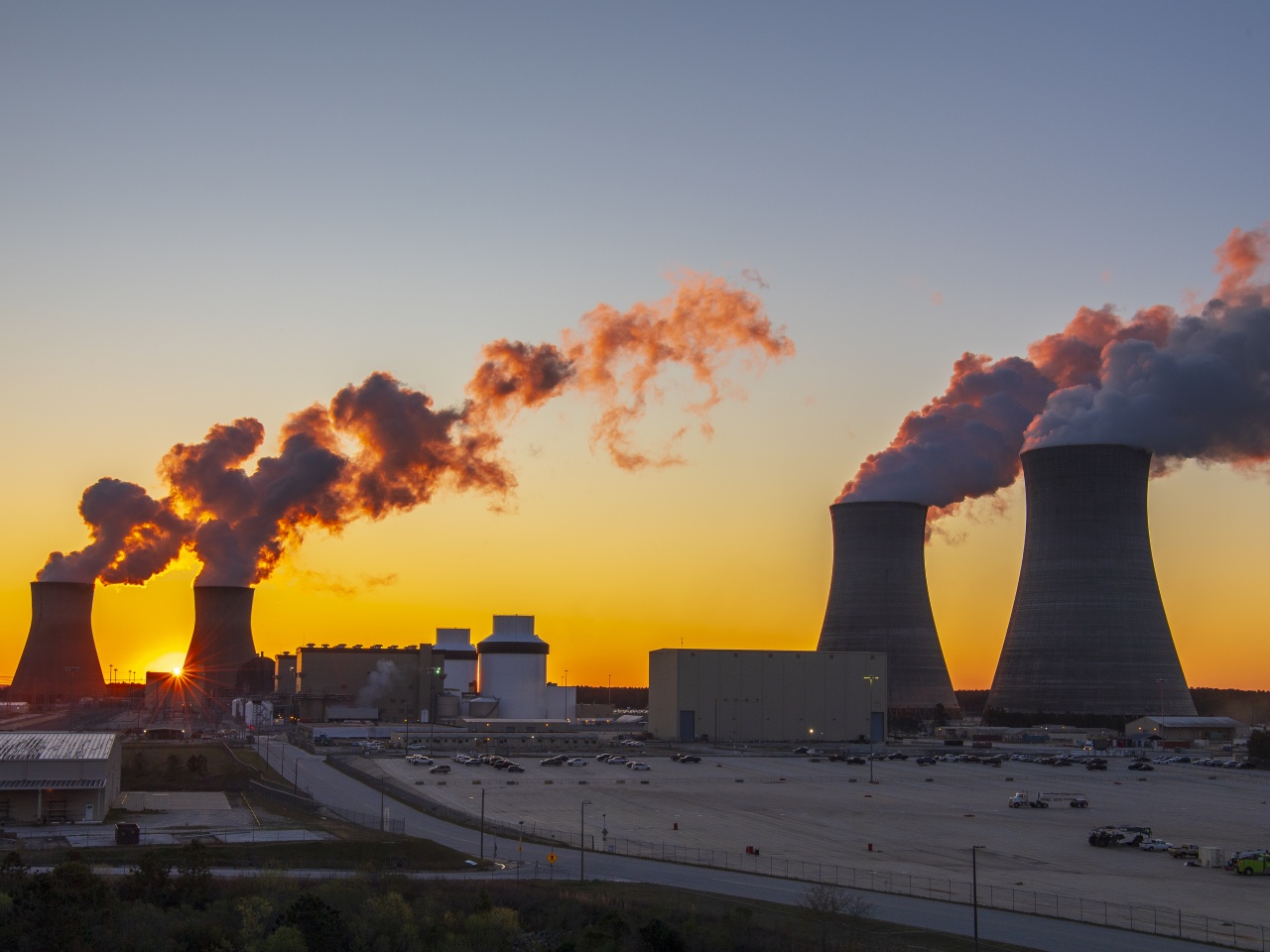 Four cooling towers at Plant Vogtle send plumes into the sky above the nuclear generating site