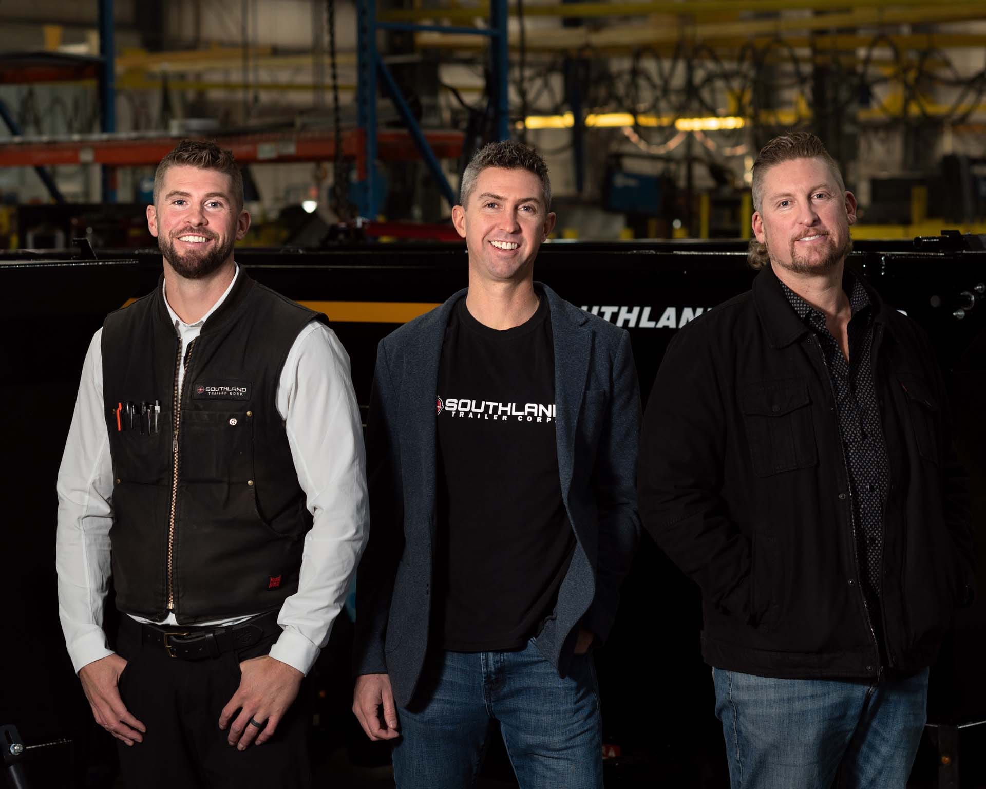 The three Sailer brothers standing in a Southland Trailers factory