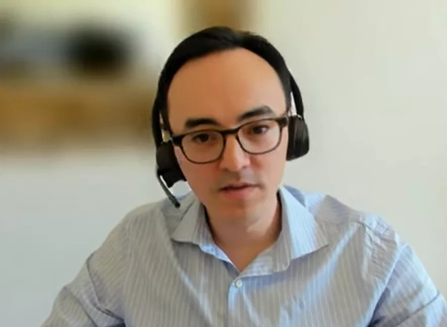 Sovan Bin wearing glasses and a headset during a remote interview