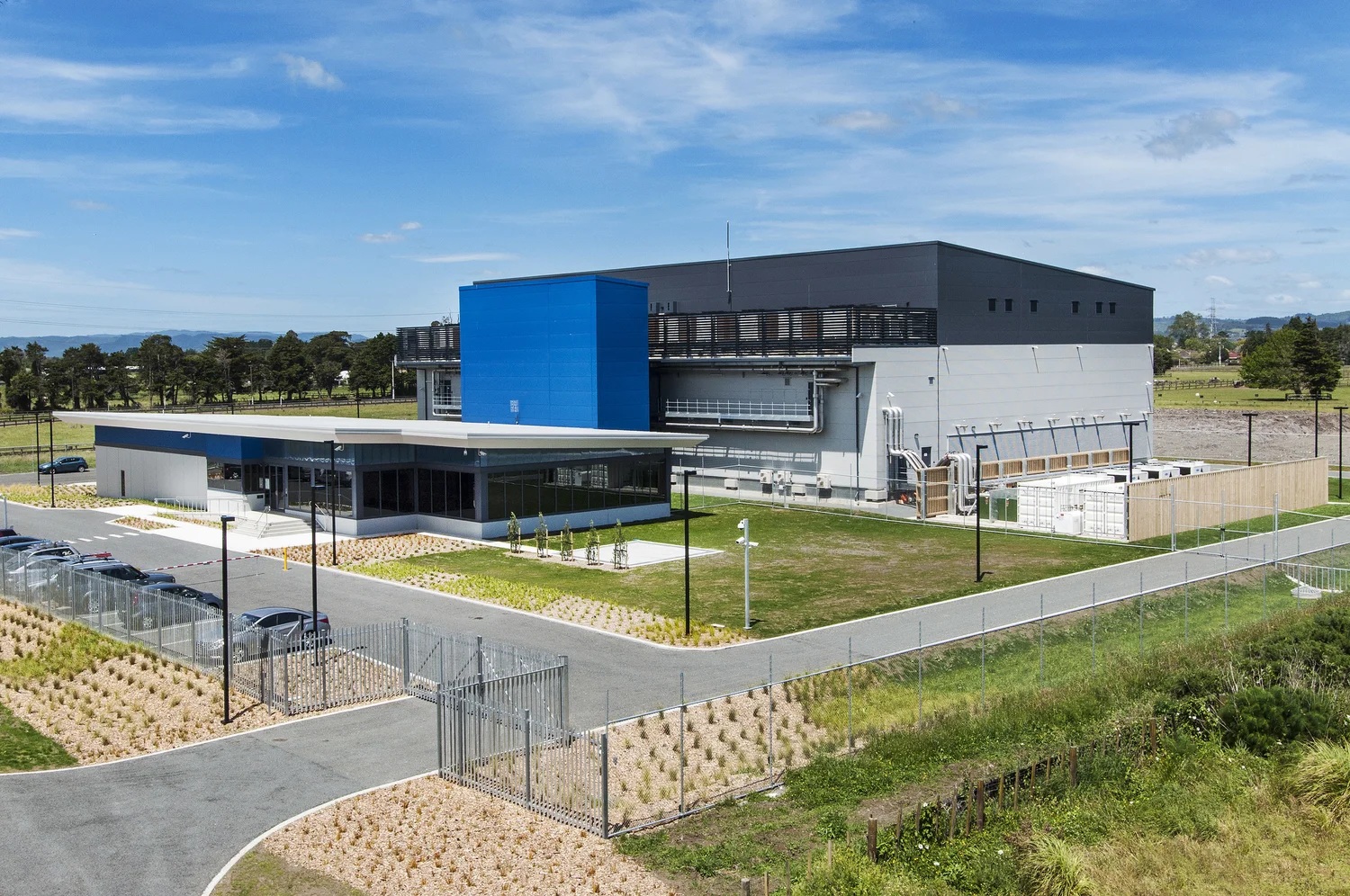 Spark data-centre facility with blue and grey exterior, landscaped grounds and security fencing