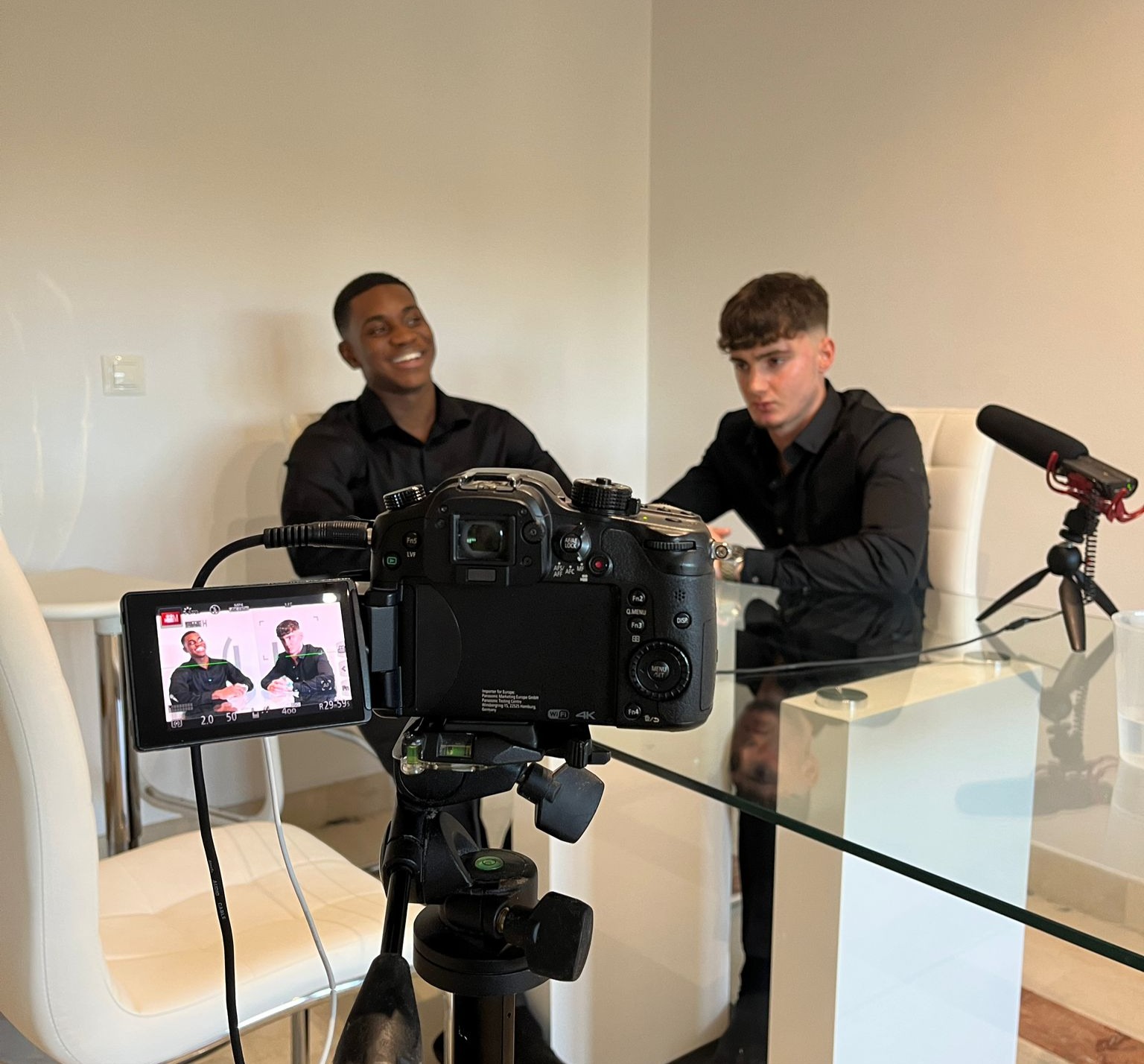 Spark Tutoring founders seated behind a camera during filming