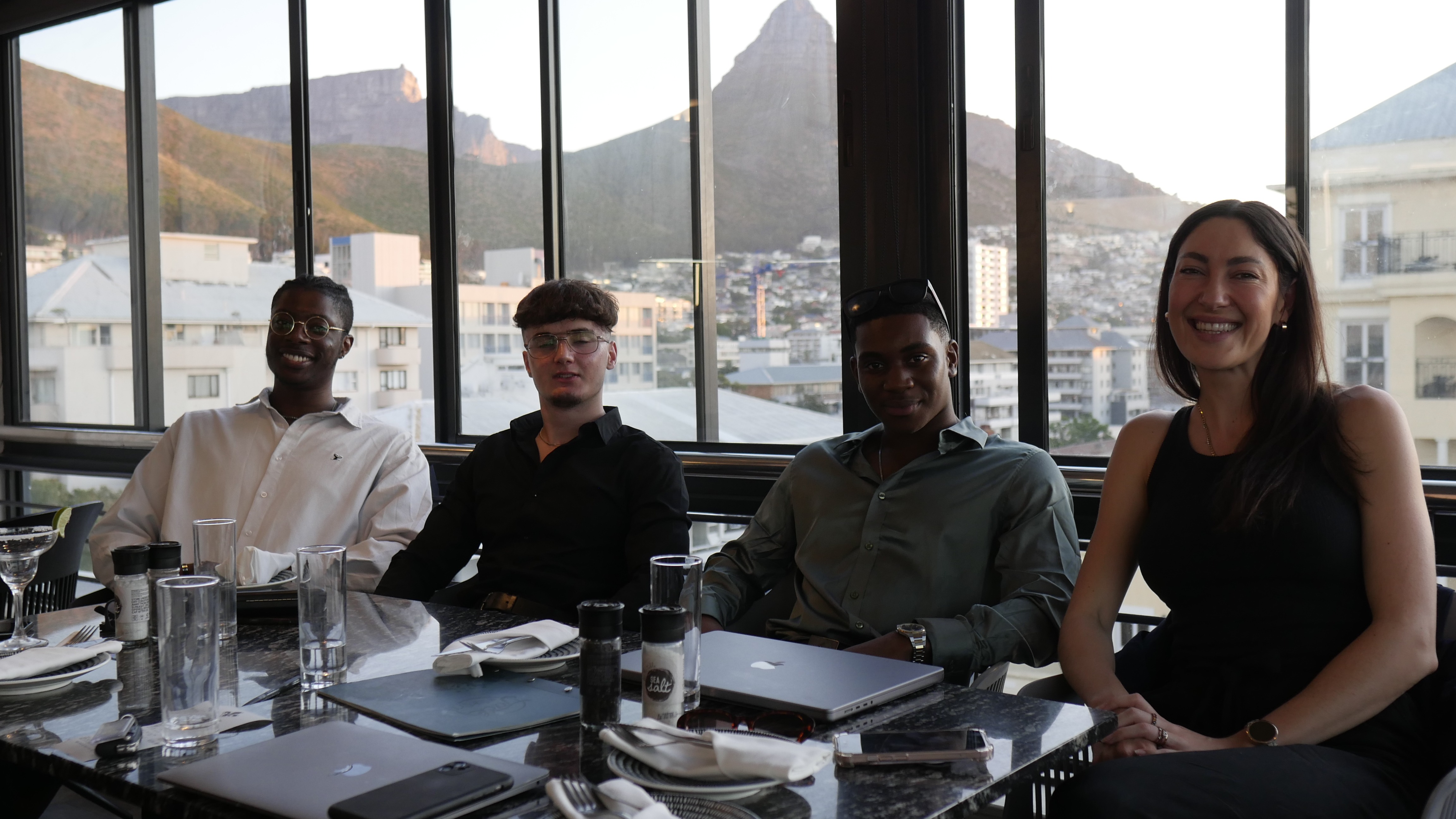 Four members of Spark’s team at a restaurant with Cape Town mountains behind them