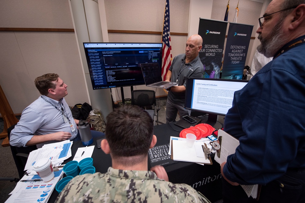 Visitors examine a Parsons cyber technology demonstration at a Navy exercise in Charleston