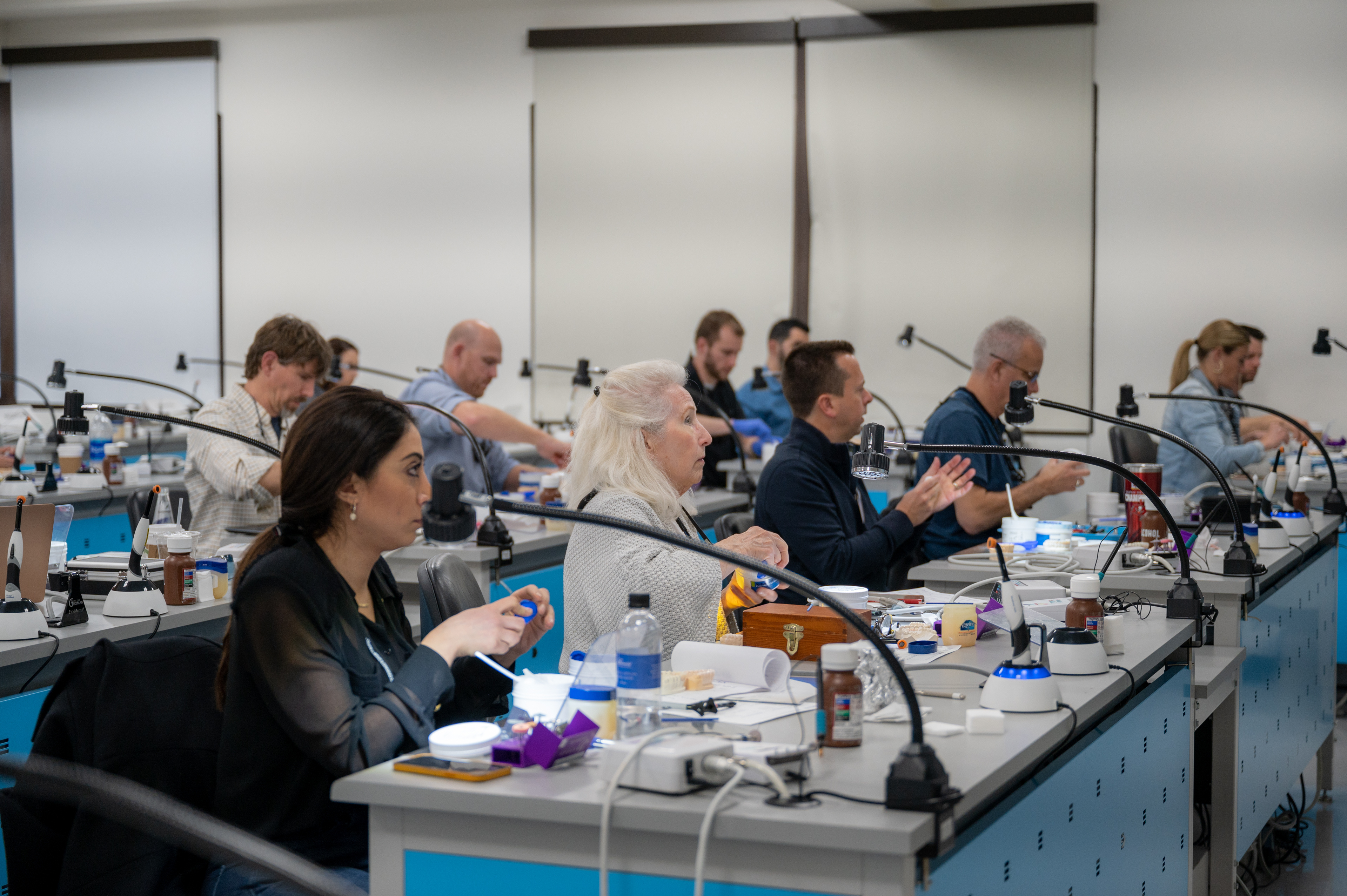 Dental professionals working at illuminated benches during a Spear restorative workshop