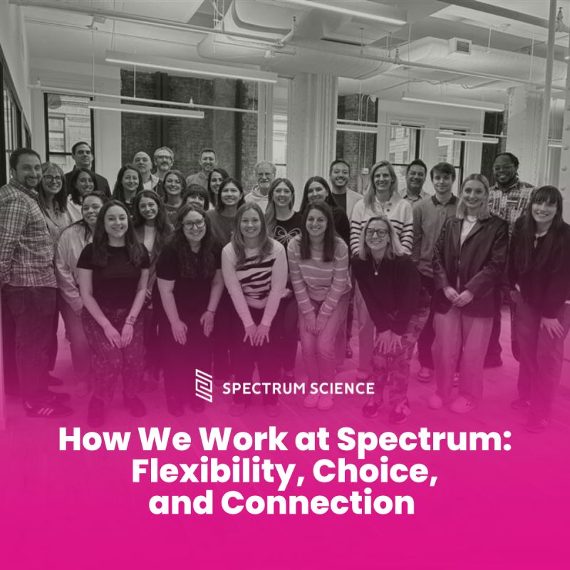 Spectrum Science colleagues gathered in a bright office beneath a sign about flexibility, choice and connection