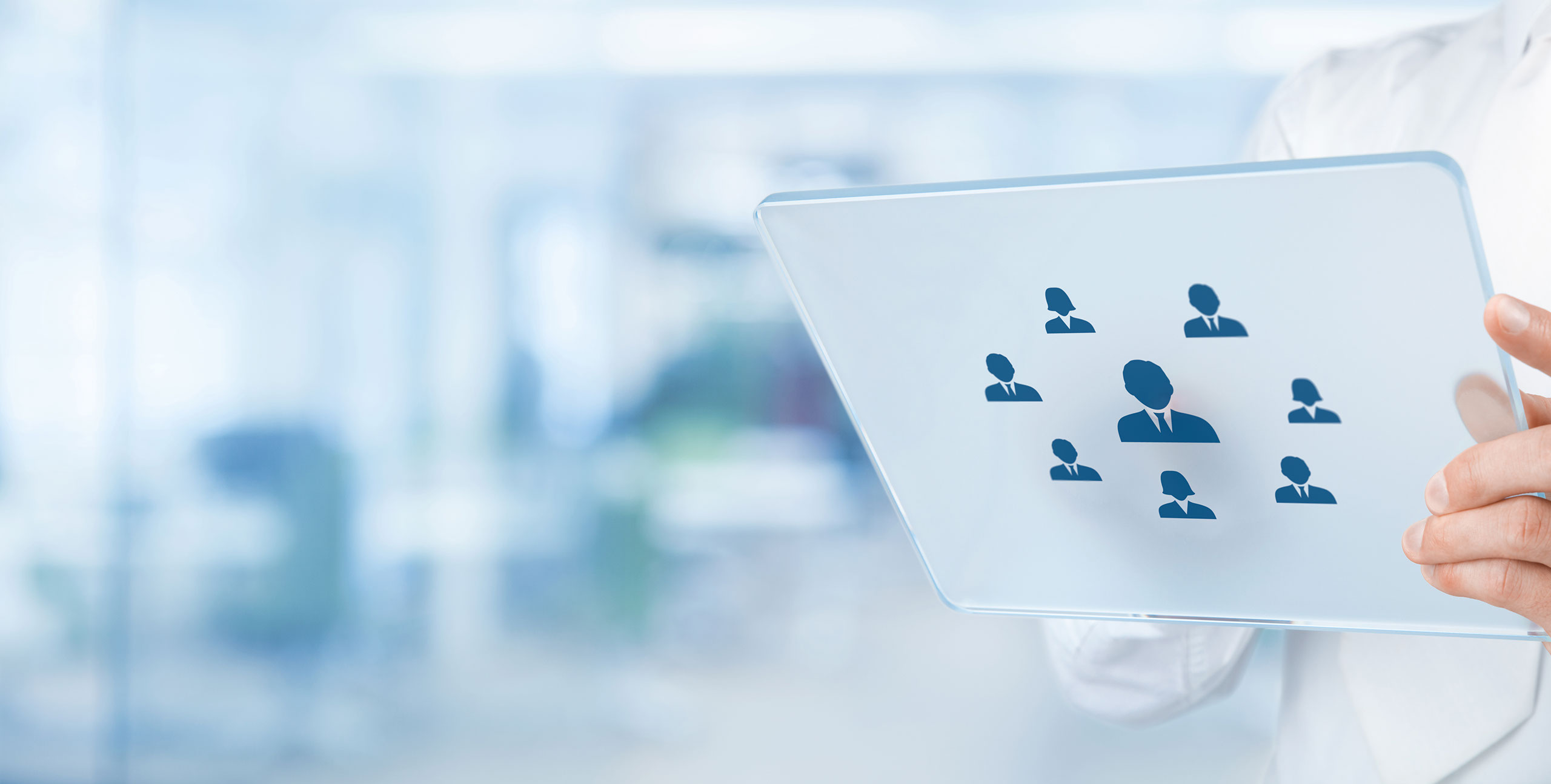 A hand holding a transparent panel with a network of professional figures