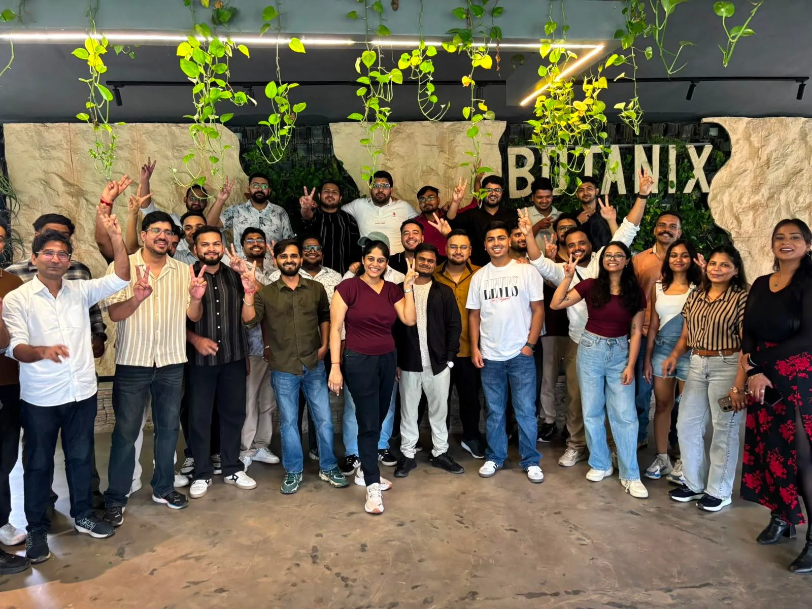Spektra team gathered for dinner beneath hanging greenery
